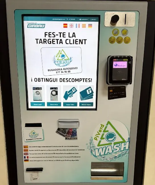 La central de pago: pantalla táctil arriba a la izquierda, monedero y datáfono a la derecha, ranuras para la tarjeta cliente y los billetes a media altura, y salidas del recibo y del cambio abajo